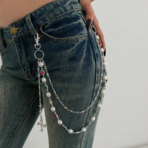 Macro view of multi-layer chain with pearls, colorful gems, and diamond cross pendant