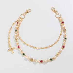 Detail of multilayer gold chain with colorful rhinestones, pearls and a cross pendant