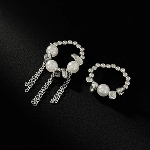 Λεπτομέρεια από ασημί σκουλαρίκι ear cuff με λευκές πέρλες και μακριές αλυσίδες με κρόσσια