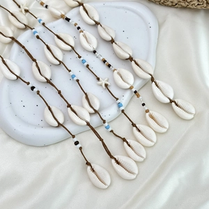Détail de l'élastique à cheveux bohème avec coquillages, perles bleues et étoiles de mer