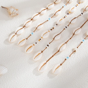 Détails de cordes à cheveux bohèmes avec coquillages, étoiles de mer et perles