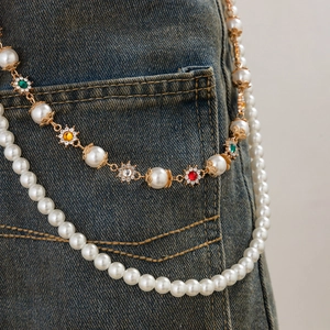 Macro detail of multi-layered waist chain with faux pearls and colorful floral gemstones