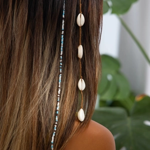 Détail de tresse de cheveux bohème avec perles colorées et coquillages naturels