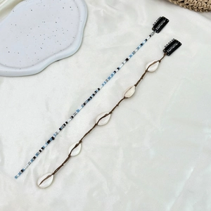 Vue détaillée de cordes à cheveux bohèmes avec coquillages et perles tressées
