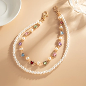 Close-up of pearl chain and colorful heart gemstone charms with gold lobster clasp