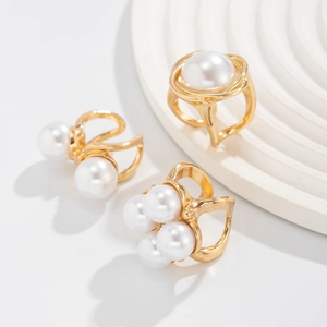 Detailed macro view of gold-plated baroque rings with multiple round white faux pearls