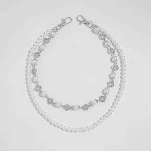 Detail of double-layer pearl chain featuring silver clover accents and lobster clasps