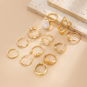 Set of 12 gold plated irregular rings featuring large baroque pearl and textured bands