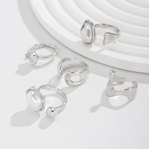 Detailed view of 5-piece silver ring set with irregular lines and white pearls