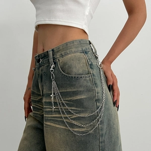 Detail view of multi-layer metal pants chain with silver star pendants on denim jeans