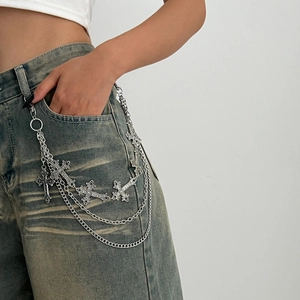 Detail of silver multi-layered metal pants chain with cross pendants on denim jeans