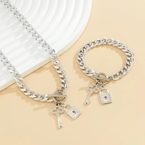 Detail van zilveren Cubaanse kettingset met strass hartslot en sleutelhanger hangers