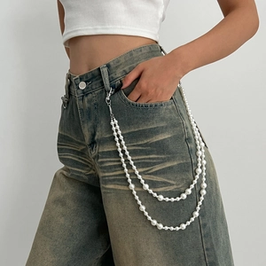 Double-layered white faux pearl waist chain with silver lobster clasps on denim jeans
