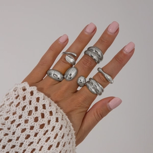 Bagues en métal argenté poli aux formes organiques fluides avec une esthétique minimaliste