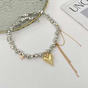 Dettaglio della collana con ciondolo a cuore, frange metalliche e perline in vetro