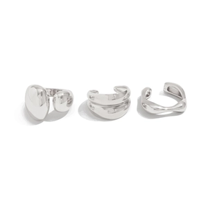 Détail d'une bague goutte d'eau argentée et de boucles d'oreilles en métal poli