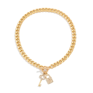 Detail van gouden Cubaanse schakelketting met diamant ingelegde sleutel- en slotbedel en OT-sluiting