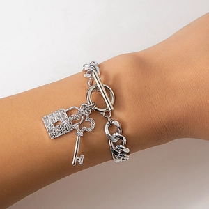 Macro detail van zilveren toggle armband met kristallen slot en hartvormige sleutel