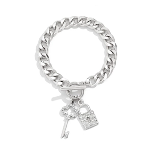 Detail van zilveren schakelarmband met T-sluiting en hart- en sleutelbedeltjes met strassteentjes