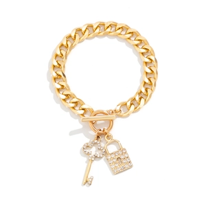 Detail van gouden cubaanse ketting met strass steentjes op de sleutel en slot hangers set