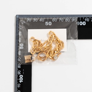 Detail van gouden ketting met hangslot hanger en OT-sluiting gemeten op een schaal