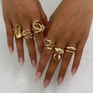 Ensemble de bagues dorées minimalistes aux designs géométriques et croisés sur les mains