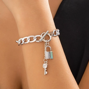 Detail van zilveren ketting met T-sluiting en hangers in de vorm van slot en sleutel