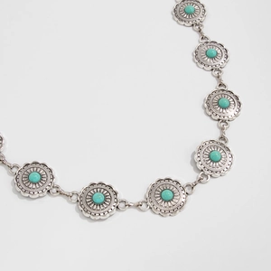 Detailed macro shot of vintage silver floral engravings with turquoise stone inlays