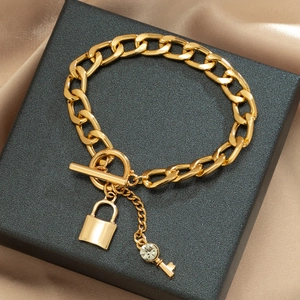 Detail van de gouden schakelketting met strass sleutel en hangslot hangers van metaal