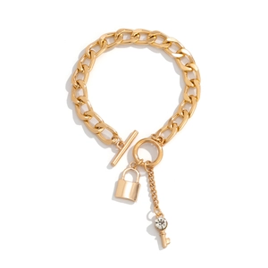 Detailopname van goudkleurige schakelketting met hartslot en sleutelhanger