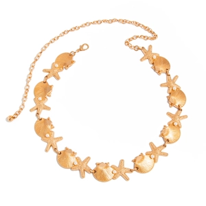Détail de la chaîne de taille dorée avec coquillages, étoiles et perles d'imitation