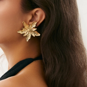 Macro view of gold liquid lava flower earring with textured metallic floral petals