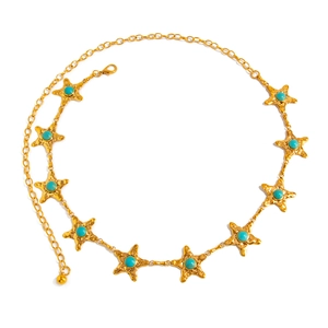 Détail de la chaîne de taille étoile de mer dorée avec perles turquoise et fermoir mousqueton