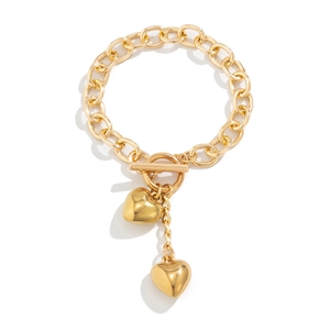 Detailopname van gouden dikke kettingarmband met OT-kneppelsluiting en hartjeshangers