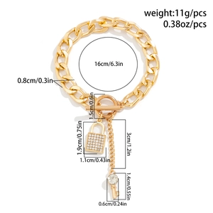 Detailgegevens van gouden kettingarmband met OT-sluiting en kristallen slotbedel