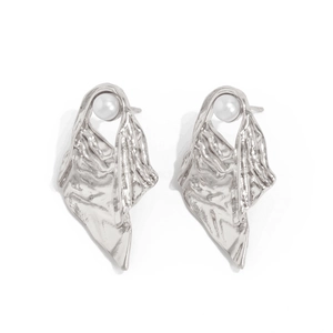 Detail of silver liquid lava earrings with metallic texture and white pearl accents