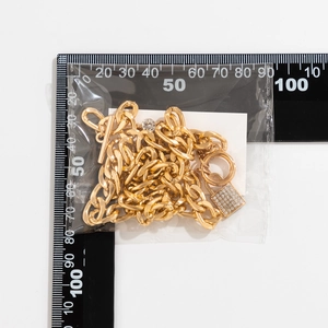 Macro-opname van de gouden dikke ketting met een iced-out hangslot en T-bar sluiting