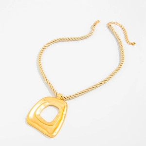 Detailansicht eines großen goldenen geometrischen Anhängers mit flüssiger Metallstruktur