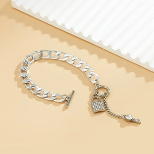 Detail van zilveren schakelarmband met strass slotje, sleutelhanger en T-sluiting systeem