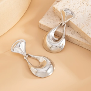 Detail of silver liquid lava metal drop earrings with hollow teardrop design and geometric texture