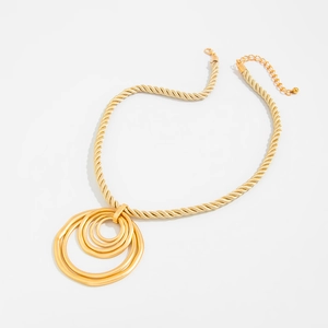 Makroansicht goldener strukturierter Ring-Anhänger mit dicker gedrehter Kordelkette