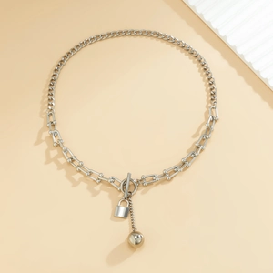 Detail van zilveren schakelketting met U-schakels en een slotje als hanger