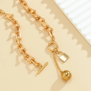 Detail van de gouden U-schakelketting met gepolijste slot-hanger en bal aan T-sluiting