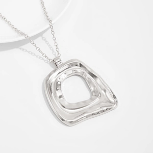 Nahaufnahme der silbernen geometrischen Blumenkette mit gehämmerter Metalloberfläche