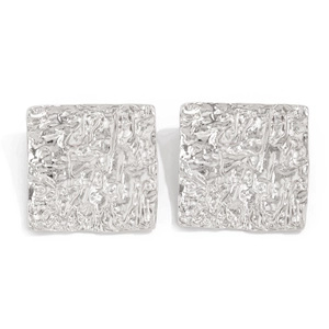Macro shot of silver square earrings featuring a liquid lava texture and hammered metal finish