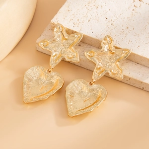 Macro detail of gold flower and heart earrings with molten lava metal texture