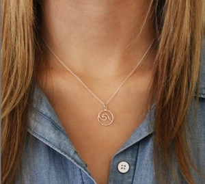 Zilveren roestvrijstalen golfketting getoond op een model met een blauw shirt achtergrond
