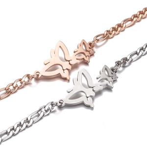 Détail de bracelets papillon en acier inoxydable or rose et argent sur fond blanc pur