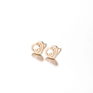 Detail of hollow heart-shaped gold stud earrings with elegant cutout metal design