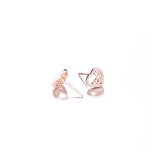Macro view of rose gold heart stud earrings with minimalist hollow design for women